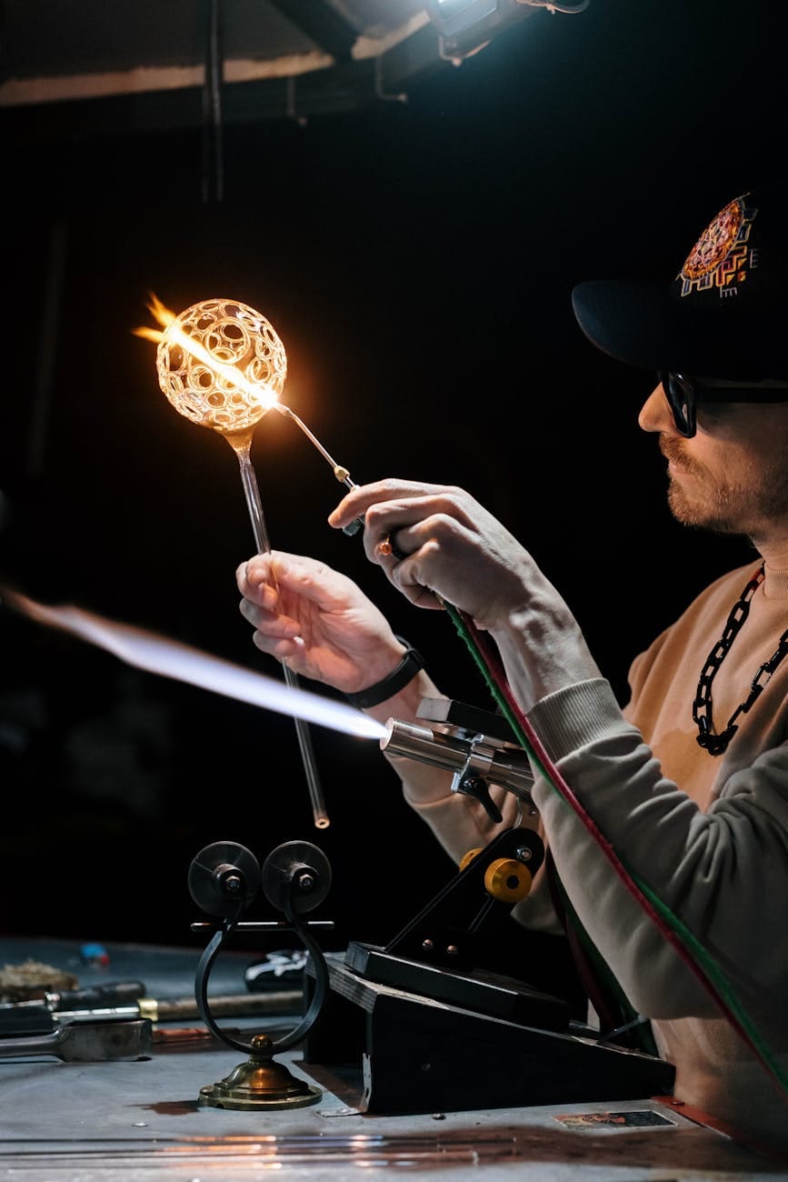 man heating a glass item with a torch